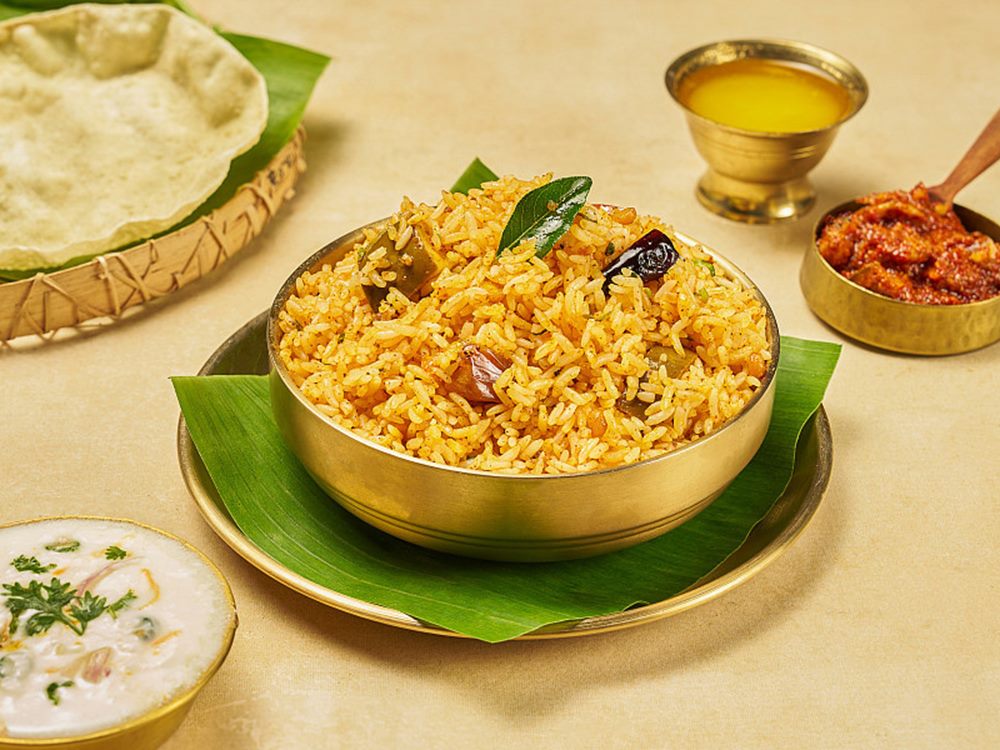 Avakaya rice served in brass with mango pickle and ghee