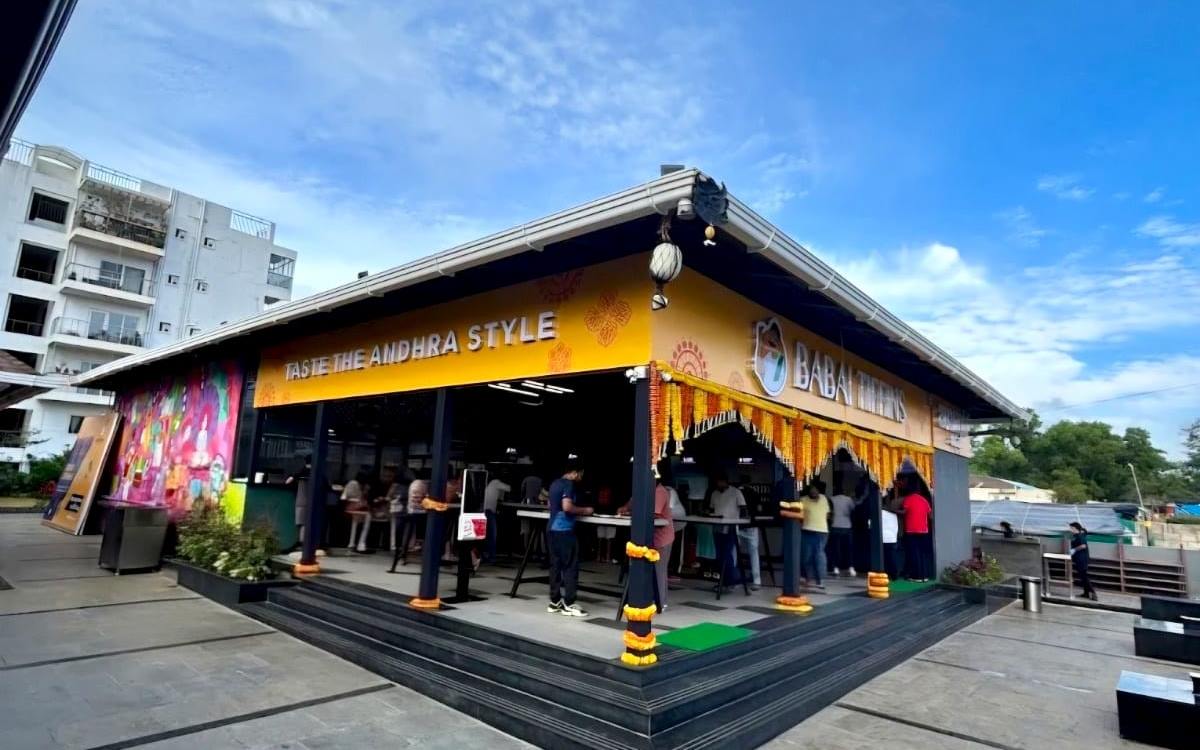 Babai Tiffins Sarjapura, the open yellow frontage under its pitched roof with customers at the counter